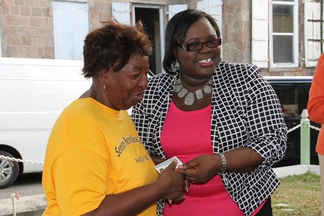 Junior Minister in the Ministry of Social Development Hon. Hazel Brandy-Williams handing out an official identification card for the Ministry’s Seniors Subsidized Transportation Programme to one of the 150 seniors registered for the programme